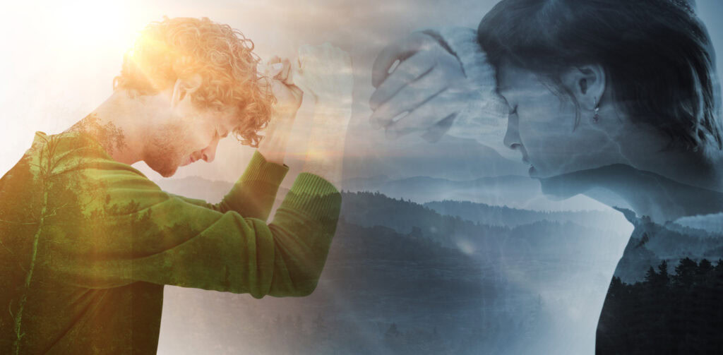 Sad pretty brunette leaning against wall against trees and mountain range against cloudy sky