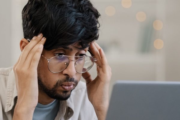 Ill arab business man student male bearded boss leader with glasses guy works with laptop problems suffers from headache massages head feeling stress solves difficult trouble searching solution. High quality photo